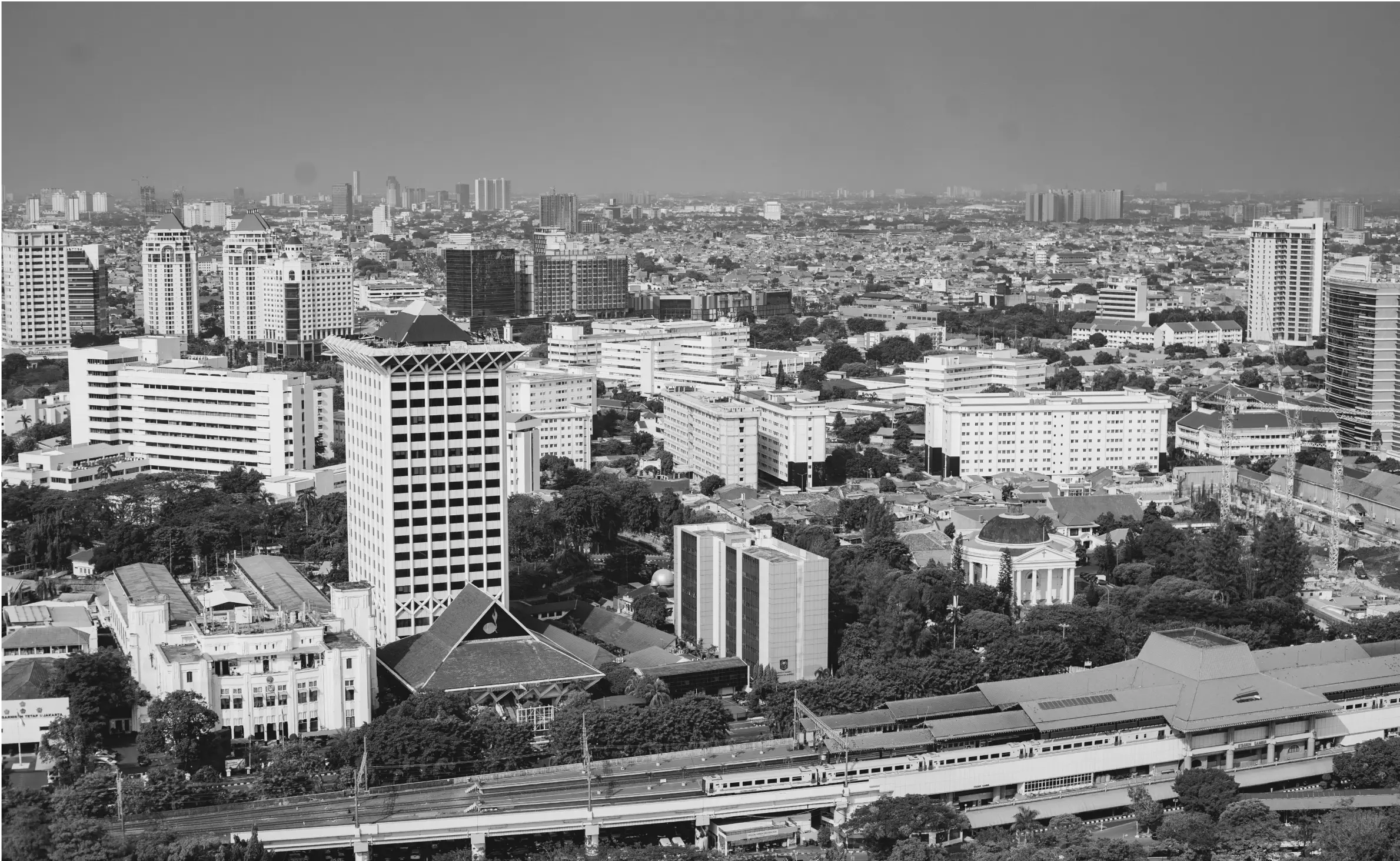 A monochrome cityscape of tall buildings and residential areas.